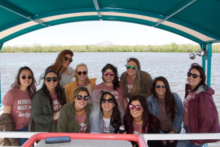 a group of people posing in front of a body of water